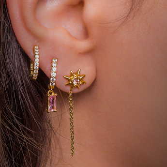 a woman posing with gold hoop earrings